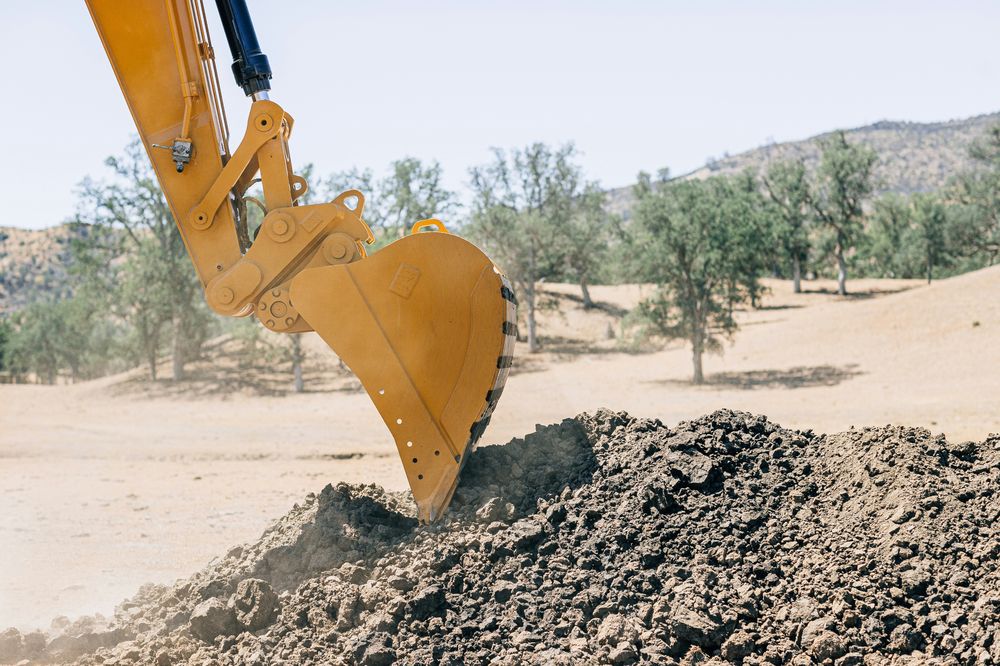 Excavator bucket digging soil at an excavation site