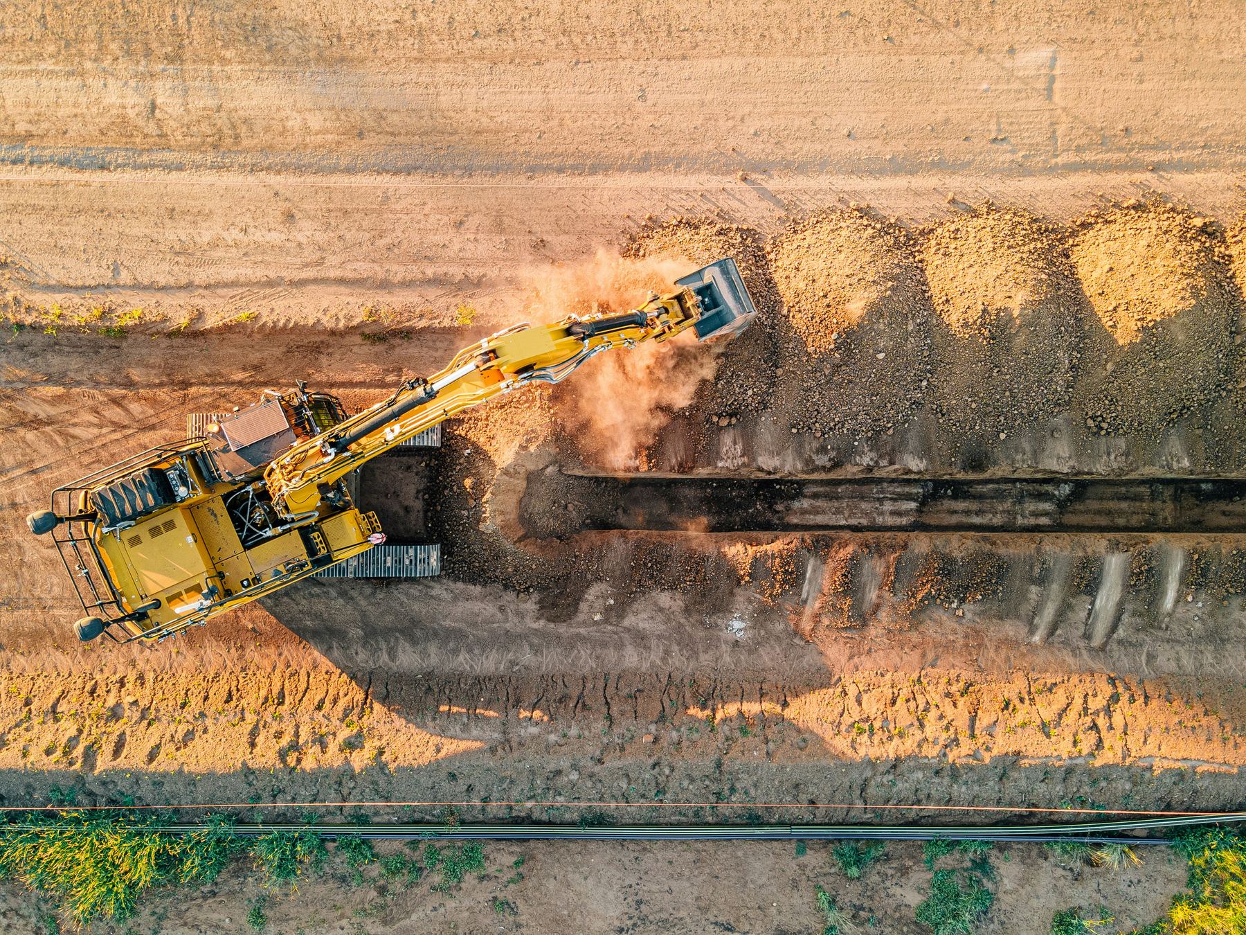 Aerial view of an excavator digging a trench